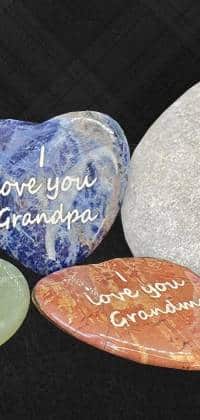 Red and blue polished engraved heart shaped stones with text, I love you grandpa, I love you grandma.