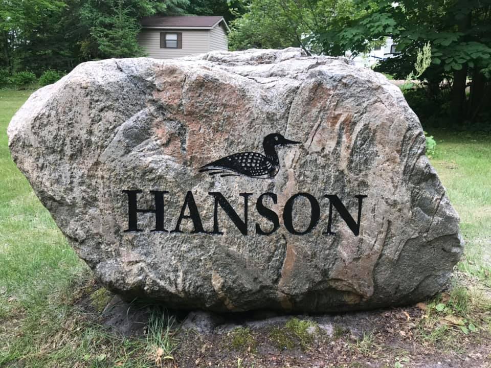 Large gray rock with engraving text, Hanson. Includes engraved design of a loon.