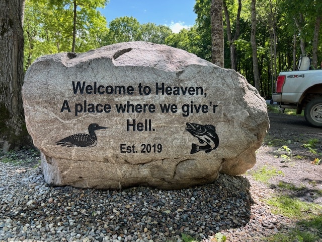 Large engraved stone that says, Welcome to Heaven A place where we giver Hell.