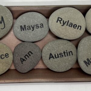 A wood box full of eight engraved rocks that have names of everyone in the family.