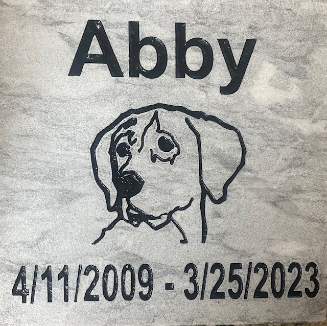 Engraved pet memorial that says Abby 04/11/2009 - 03/25/2023. Custom dog graphic.