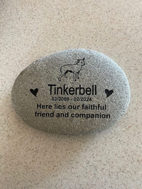 Pet memorial engraving that says "Tinkerbell 03/2008 - 02/2024 Here lies our faithful friend and companion"