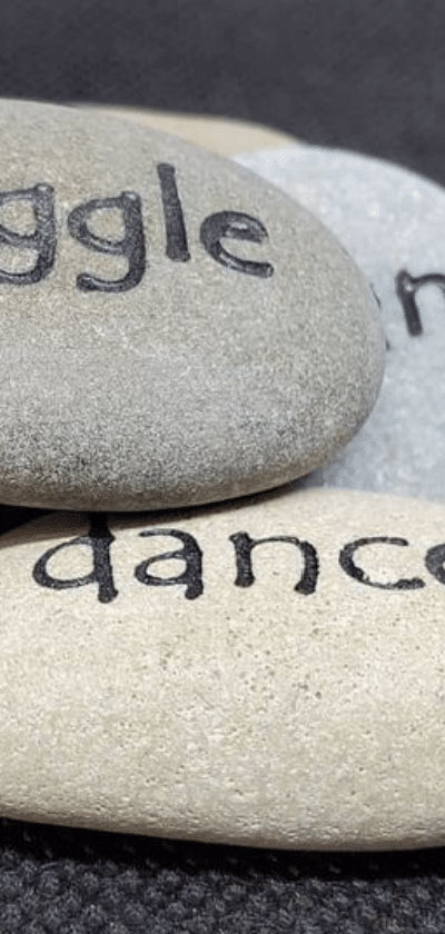 Small engraved rocks with text, dance, and giggle