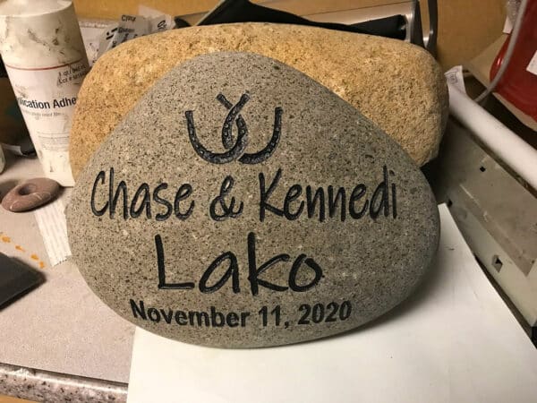 Custom engraving on a brown rock that says chase and kennedi lako, November 11, 2020