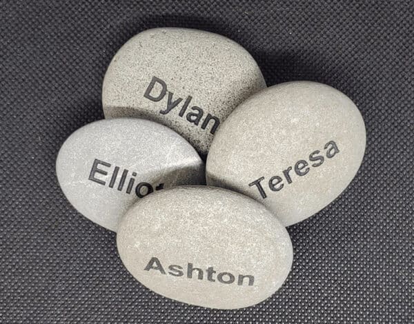 Name Rocks White name rocks, front rock has the name Ashton engraved on it. Back rocks says Dylan, right rock says Teresa, left rock says Elliot
