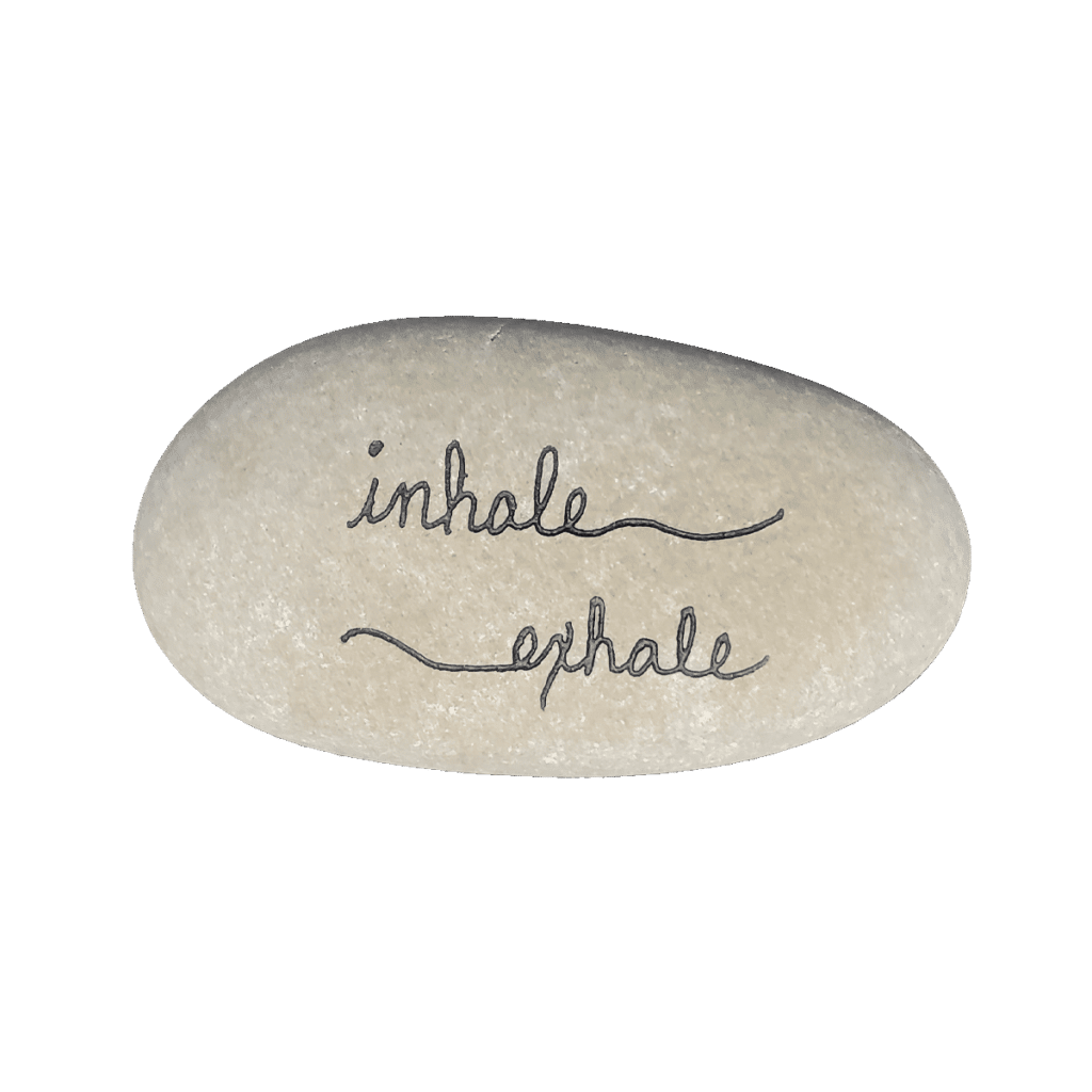 White engraved stone that says inhale, exhale