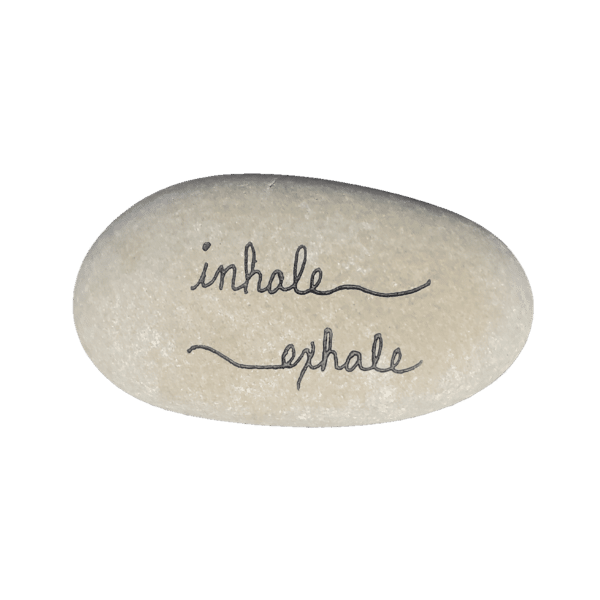 White engraved stone that says inhale, exhale