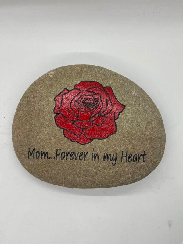 Custom engraved rock that shows an engraved rose that is painted red and black with the saying mom... Forever in my heart