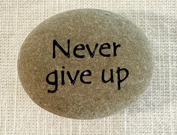 Inspirational stones - stone with Never give up engraved on it.